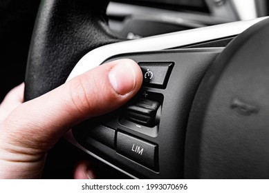 Hand Pushes Cruise Control Button On Steering Wheel.