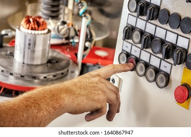 A hand pushes the stop button of a robot machine that winds and 