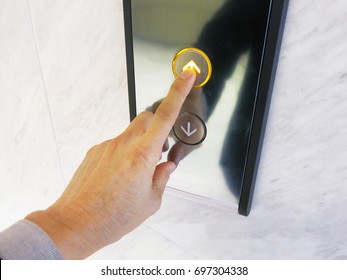 Hand Pushing Up Arrow Elevator Button.
