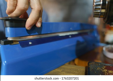 Hand pushing bag sealing machine for closing the paper product package - Powered by Shutterstock