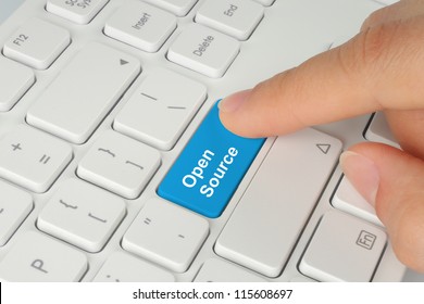 Hand pushing blue open source keyboard button
