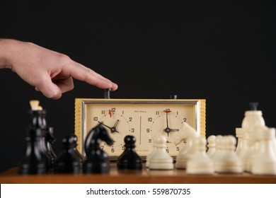 Hand Pushing Chess Time Clock. Playing Quick Chess With Timer On Dark Background