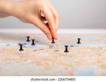 Hand Pushing Pin On Paper Map. Trip Planning, Marking Travel Destination, Location With Pushpin. High Quality Photo