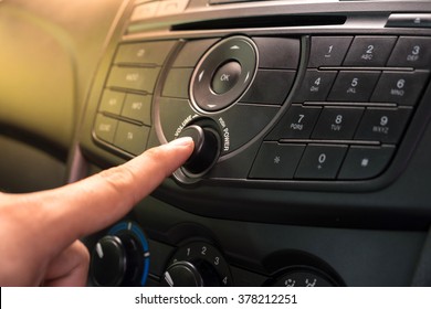 Hand Pushing The Power Button To Turn On The Car Stereo System