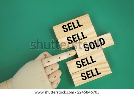 hand pushing stick with word sold in sell line. the concept of sell and sold. the concept of a house or item has been sold