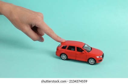 Hand Pushing Toy Car Model On Blue Background