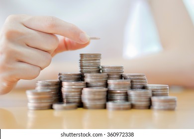 Hand Put Coins To Stack Of Coins On White Background