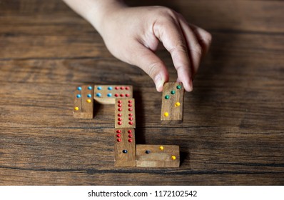 hand put domino on wood table, young people playing domino games, puzzle game - Shutterstock ID 1172102542
