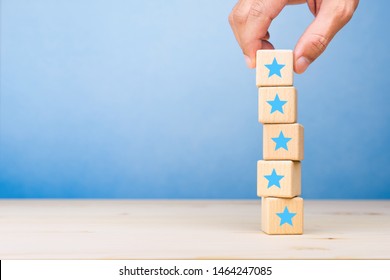 Hand put wooden blocks stacking with the five star symbol on the table, evaluation, Increase rating, Customer experience, satisfaction and best excellent services rating concept. copy space