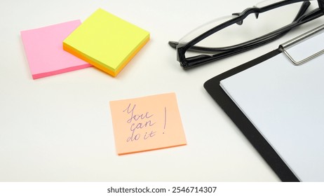 A hand puts a sticker with a motivational text on the office desk. planning concept, motivation, positive message, motivation of the year - Powered by Shutterstock