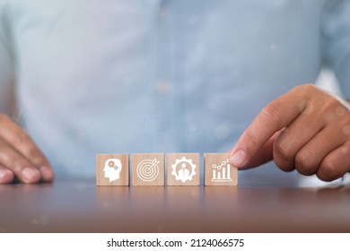 Hand puts wooden cubes with knowledge, skills, experience, performance and goals icon on grey background with .copy space. Banner competence, skills and knowledge concept.