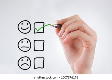 Hand Putting Check Mark With Green Marker On Customer Service Evaluation Form