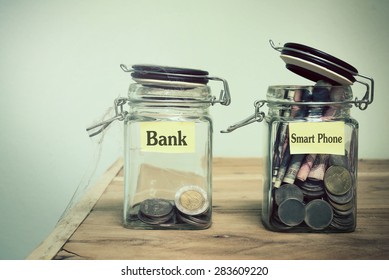 Hand Putting A Coin Into Glass Jars