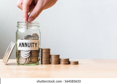 Hand Putting Coin In Jar Word Annuity With Money Stack, Concept Business Finance And Investment