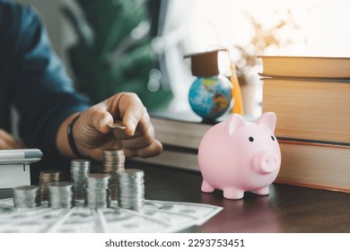 Hand putting coin on stack with piggy bank. Concept of saving money for a scholarship to study abroad at a university level. Financial planning accounting ideas for future education.