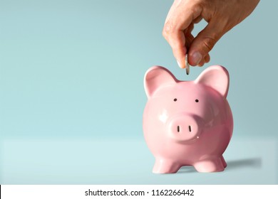 Hand putting coin to piggy bank