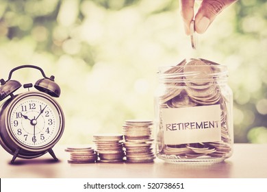 Hand Put Coins in Glas Glas Glas mit Retro-Wecker für Zeit zu Geld sparen für Pensionskurs Konzept, Retro-Farbton Vintage