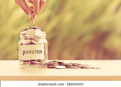 Hand putting Coins in glass jar  for time to money saving for pension concept , vintage retro color tone - Shutterstock ID 583541419