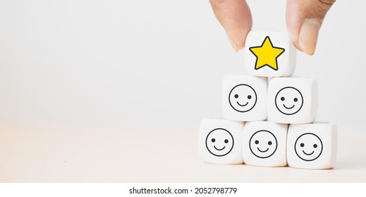 Hand putting dice cube with icon face smiley feedback, best excellent business services rating customer experience, Satisfaction survey.kid evaluation reward, encourage.Mental health, child emotion. - Shutterstock ID 2052798779
