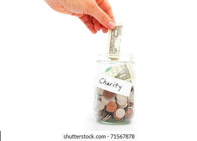 Hand Putting A Dollar Into A Jar - Charity Donation