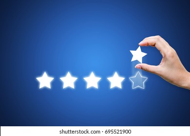 Hand Putting Five Star Symbol To Increase Rating Of Company With Dark Blue Background, Copy Space For Text Or Headline