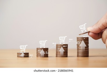 Hand putting to increase coins stacking with up arrow and virtual white shopping cart for business growth and increasing of shopping sale volume concept. - Shutterstock ID 2180065941
