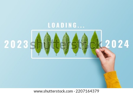 Hand putting leaf for countdown to 2024. Loading year 2023 to 2024. Start concept