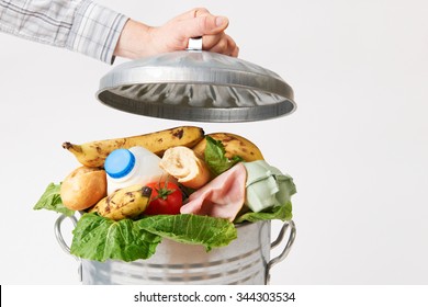 Hand Putting Lid On Garbage Can Full Of Waste Food