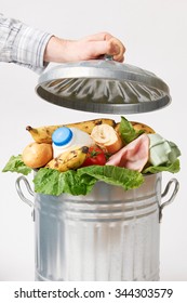 Hand Putting Lid On Garbage Can Full Of Waste Food