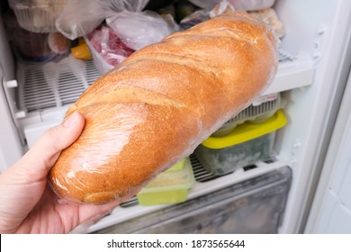 A Hand Putting A Loaf Of Wheat Bread In Reserve On A Shelf Of A Home Freezer, Long Life Food Storage Concept.