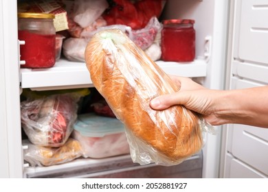 A Hand Putting A Loaf Of Wheat Bread In Reserve On A Shelf Of A Home Freezer, Long Life Food Storage Concept