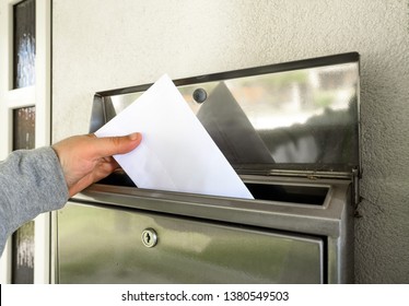 Hand Putting Mail In Mailbox
