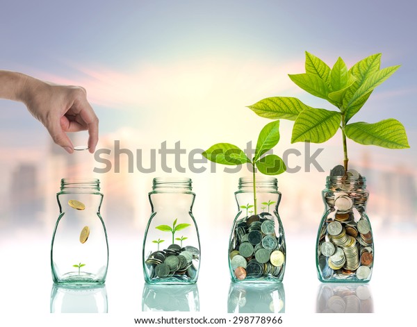 Ручной кладок монет и семян в прозрачную бутылку на городском фоне фото размытый городской пейзаж, концепция роста инвестиций в бизнес