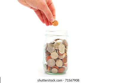 Hand Putting Penny In A Coin Jar, Saving Money
