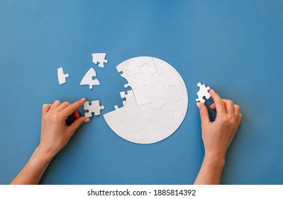 Hand putting piece in round puzzle