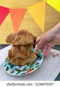 Hand Putting Plate Of Croissants On Birthday Table Closeup