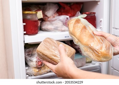 A Hand Putting Two Loafs Of Wheat And Brown Bread In Reserve On A Shelf Of A Home Freezer, Long Life Food Storage Concept.