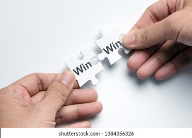 Hand Putting Two Pieces Puzzle Together With Word Win Win Situation