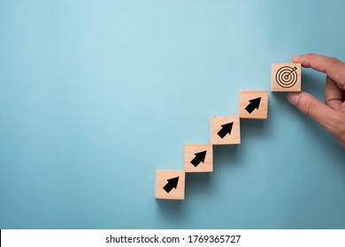 Hand putting virtual target board and arrow which print screen on wooden cube. Business achievement goal and objective target concept. - Shutterstock ID 1769365727