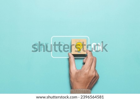 Hand putting wood cube with light bulb icon on green background. On and off toggle switch button. Concept of innovation idea and technology