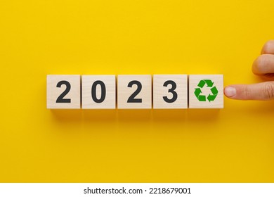 Hand putting wooden blocks with recycling icon and 2023 on yellow background. Concept of recycling, waste processing, caring for the planet. - Shutterstock ID 2218679001