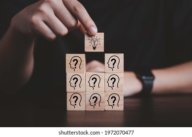 Hand putting wooden cube block stacking which print screen light bulb and question mark with human , Creative thinking idea and problem solving concept. - Shutterstock ID 1972070477