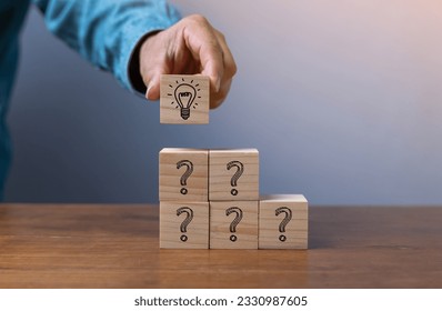 Hand putting wooden cube block stacking which print screen light bulb and question mark with human , Creative thinking idea and problem solving concept. - Shutterstock ID 2330987605