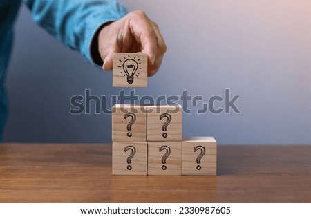 Hand putting wooden cube block stacking which print screen light bulb and question mark with human , Creative thinking idea and problem solving concept.