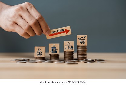 Hand putting wooden cube and inflation word a on coins in idea for FED consider interest rate hike, world economics, and inflation control, US dollar inflation - Shutterstock ID 2164897555