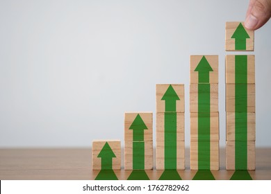 Hand Putting Wooden Cubes Block Which Print Screen Increase Or Up Green Arrow. It Is Symbol Of Economic Investment Profit Growth.