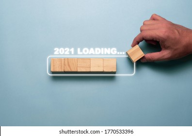 Hand Putting Wooden Cubes Block To  White Block For Count Down And Loading To 2021. Happy New Year To Start New Project And Business Concept.