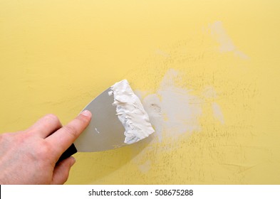 Hand With Putty Knife Repair Damaged Wall