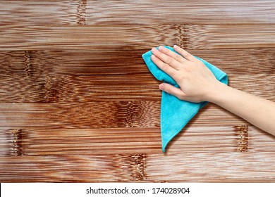 Hand With A Rag To Dust The Wood Furniture