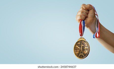 hand raised, holding gold medal with Eiffel Tower symbol against sky. award and victory concept.  - Powered by Shutterstock